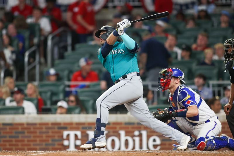 May 20, 2023; Atlanta, Georgia, USA; Seattle Mariners third baseman Eugenio Suarez (28) hits a two-run home run against the Atlanta Braves in the seventh inning at Truist Park. Mandatory Credit: Brett Davis-USA TODAY Sports