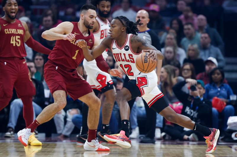 CLEVELAND, OH - FEBRUARY 14: Ayo Dosunmu #12 of the Chicago Bulls drives against Max Strus #1 of the Cleveland Cavaliers during the first half at Rocket Mortgage Fieldhouse on February 14, 2024 in Cleveland, Ohio. NOTE TO USER: User expressly acknowledges and agrees that, by downloading and or using this photograph, User is consenting to the terms and conditions of the Getty Images License Agreement. (Photo by Ron Schwane/Getty Images)