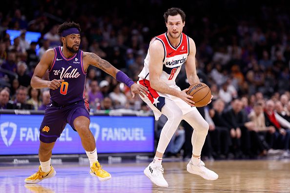 PHOENIX, ARIZONA - DECEMBER 17: Deni Avdija #8 of the Washington Wizards drives against Jordan Goodwin #0 of the Phoenix Suns during the first half at Footprint Center on December 17, 2023 in Phoenix, Arizona. NOTE TO USER: User expressly acknowledges and agrees that, by downloading and or using this photograph, User is consenting to the terms and conditions of the Getty Images License Agreement.  (Photo by Chris Coduto/Getty Images)