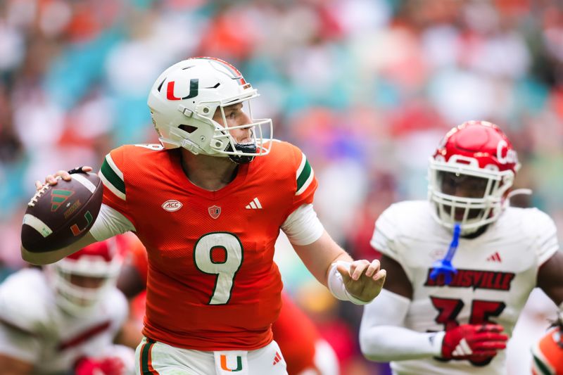 Nov 18, 2023; Miami Gardens, Florida, USA; Miami Hurricanes quarterback Tyler Van Dyke (9) looks for a passing option against the Louisville Cardinals during the second quarter at Hard Rock Stadium. Mandatory Credit: Sam Navarro-USA TODAY Sports