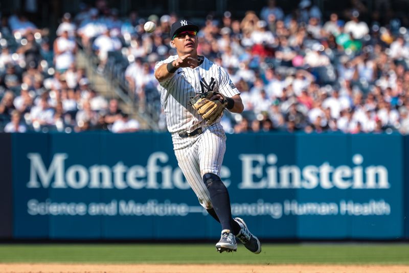 Aug 11, 2024; Bronx, New York, USA; New York Yankees shortstop Anthony Volpe (11) throws the ball to first base for an out during the eighth inning against the Texas Rangers at Yankee Stadium. Mandatory Credit: Vincent Carchietta-USA TODAY Sports