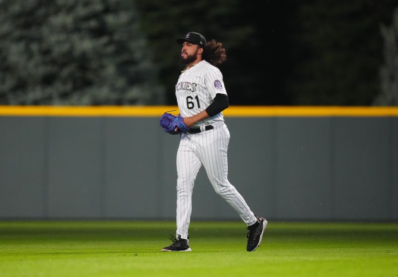 Jul 14, 2023; Denver, Colorado, USA; Colorado Rockies relief pitcher Justin Lawrence (61) runs out onto Coors Field during the ninth inning against the New York Yankees. Mandatory Credit: Ron Chenoy-USA TODAY Sports