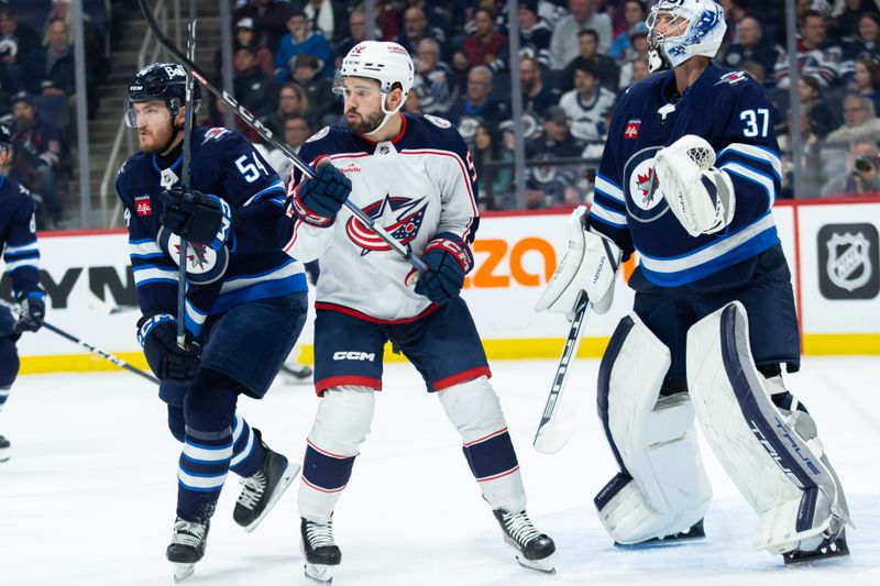 Jan 9, 2024; Winnipeg, Manitoba, CAN; Columbus Blue Jackets forward Emil Bemstrom (52) jostles for position with Winnipeg Jets defenseman Dylan Samberg (54) during the first period at Canada Life Centre. Mandatory Credit: Terrence Lee-USA TODAY Sports