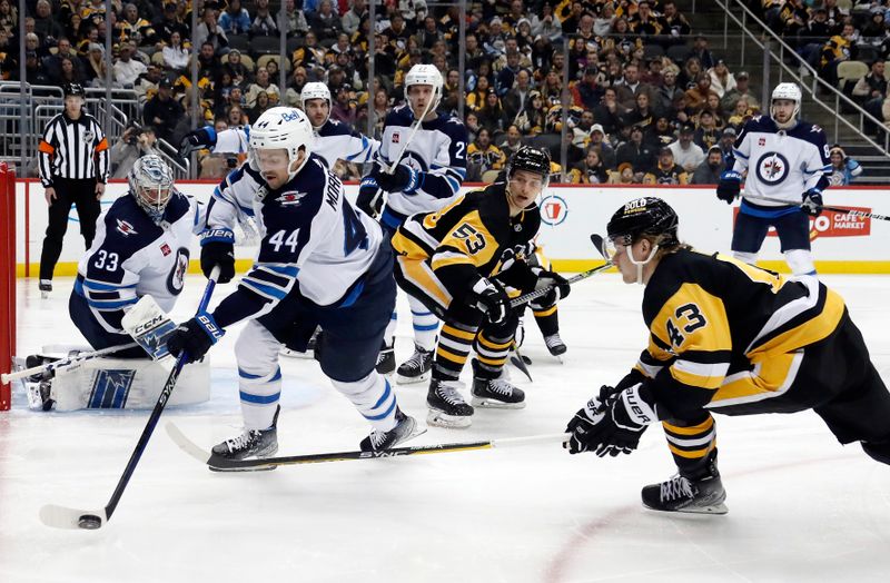 Jan 13, 2023; Pittsburgh, Pennsylvania, USA;  Winnipeg Jets defenseman Josh Morrissey (44) clears the puck against pressure from Pittsburgh Penguins left wing Danton Heinen (43) during the third period at PPG Paints Arena. The Jets won 4-1. Mandatory Credit: Charles LeClaire-USA TODAY Sports