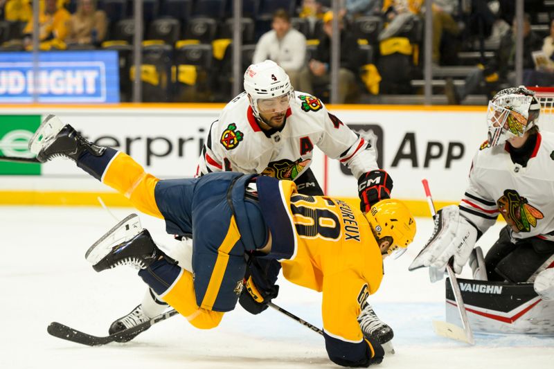 Jan 16, 2025; Nashville, Tennessee, USA;  Chicago Blackhawks defenseman Seth Jones (4) checks Nashville Predators left wing Zachary L'Heureux (68) in front of the net during the first period at Bridgestone Arena. Mandatory Credit: Steve Roberts-Imagn Images