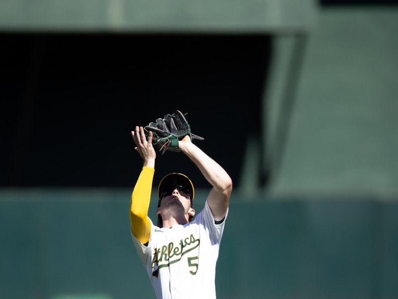 Sep 5, 2024; Oakland, California, USA; Oakland Athletics shortstop Jacob Wilson (5) makes a catch during the seventh inning at against the Seattle Mariners Oakland-Alameda County Coliseum. Mandatory Credit: D. Ross Cameron-Imagn Images