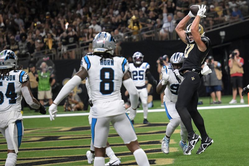 New Orleans Saints tight end Foster Moreau, right, makes a catch for a touchdown past Carolina Panthers defenders during the first half of an NFL football game Sunday, Sept. 8, 2024, in New Orleans. (AP Photo/Matthew Hinton)