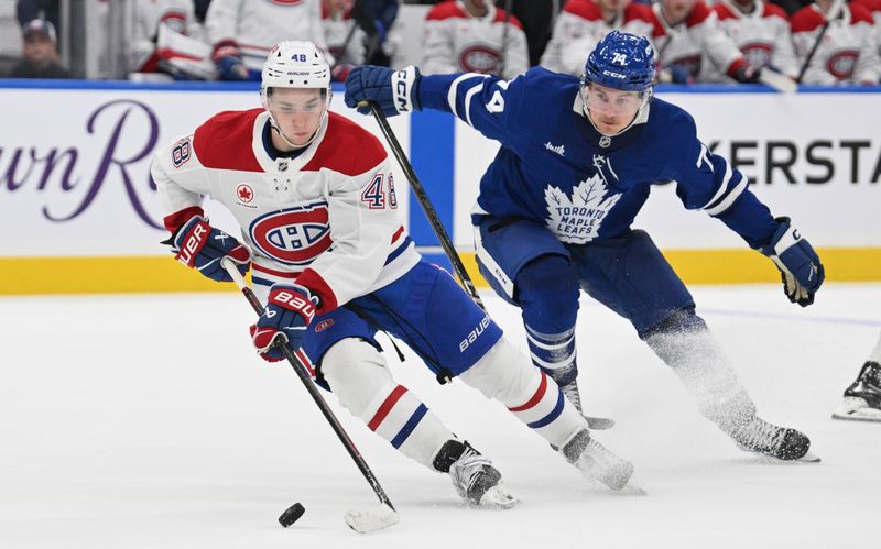 Sep 26, 2024; Toronto, Ontario, CAN;  Montreal Canadiens forward Lane Hutson (48) controls the puck in front of Toronto Maple Leafs forward Bobby McMann (74) in the third period at Scotiabank Arena. Mandatory Credit: Dan Hamilton-Imagn Images