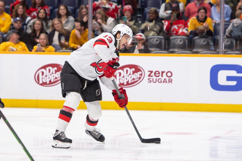 Feb 13, 2024; Nashville, Tennessee, USA;  New Jersey Devils center Nico Hischier (13) takes a shot on goal against the Nashville Predators during the second period at Bridgestone Arena. Mandatory Credit: Steve Roberts-USA TODAY Sports