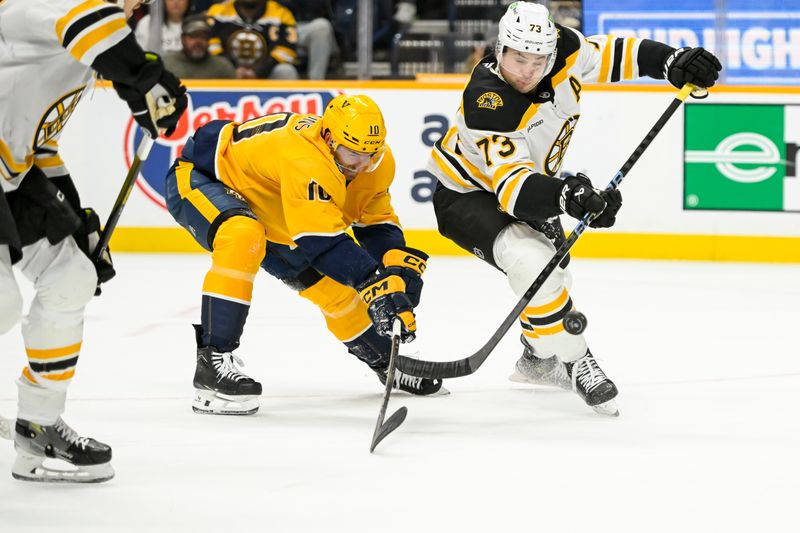 Oct 22, 2024; Nashville, Tennessee, USA;  Boston Bruins defenseman Charlie McAvoy (73) pokes the puck away from Nashville Predators center Colton Sissons (10) during the first period at Bridgestone Arena. Mandatory Credit: Steve Roberts-Imagn Images