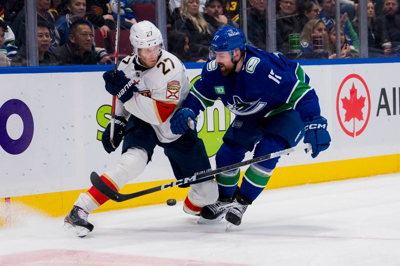 Dec 14, 2023; Vancouver, British Columbia, CAN; Vancouver Canucks defenseman Filip Hronek (17) checks Florida Panthers forward Eetu Luostarinen (27) in the second period at Rogers Arena. Mandatory Credit: Bob Frid-USA TODAY Sports