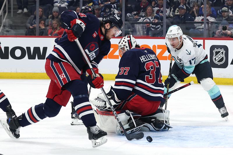 Jan 16, 2025; Winnipeg, Manitoba, CAN; wj54 and Seattle Kraken center Jaden Schwartz (17) dig for the puck behind Winnipeg Jets goaltender Connor Hellebuyck (37) in the first period at Canada Life Centre. Mandatory Credit: James Carey Lauder-Imagn Images