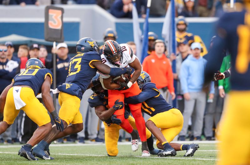 Oct 21, 2023; Morgantown, West Virginia, USA; Oklahoma State Cowboys wide receiver Rashod Owens (10) is tackled by several West Virginia Mountaineers defenders after a pass reception during the second quarter at Mountaineer Field at Milan Puskar Stadium. Mandatory Credit: Ben Queen-USA TODAY Sports