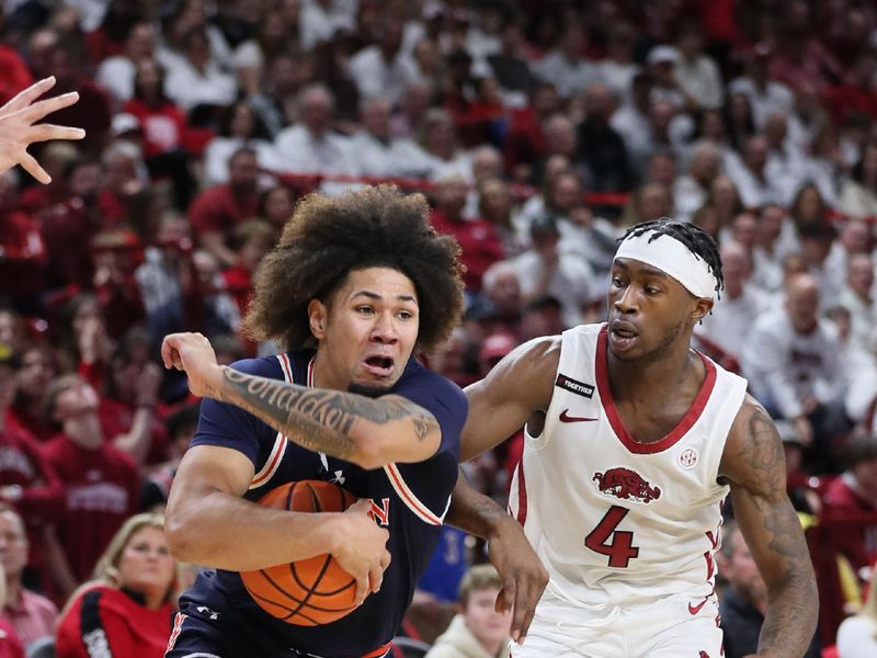 Jan 6, 2024; Fayetteville, Arkansas, USA; Auburn Tigers guard Tre Donaldson (3) drives against Arkansas Razorbacks guard Davonte Davis (4) during the first half at Bud Walton Arena. Mandatory Credit: Nelson Chenault-USA TODAY Sports