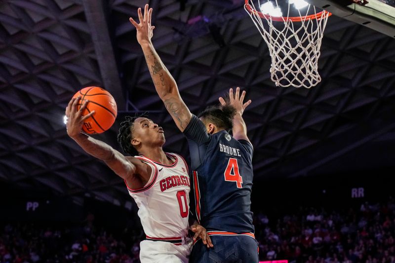 Jan 4, 2023; Athens, Georgia, USA; Georgia Bulldogs guard Terry Roberts (0) tries to score around Auburn Tigers forward Johni Broome (4) during the second half at Stegeman Coliseum. Mandatory Credit: Dale Zanine-USA TODAY Sports