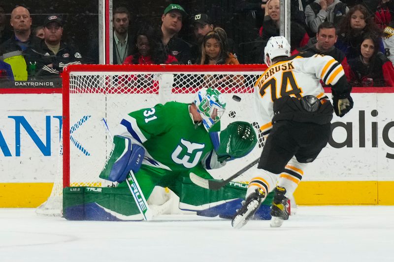 Mar 26, 2023; Raleigh, North Carolina, USA;  Boston Bruins left wing Jake DeBrusk (74) scores a shoot out goal past Carolina Hurricanes goaltender Frederik Andersen (31) at PNC Arena. Mandatory Credit: James Guillory-USA TODAY Sports