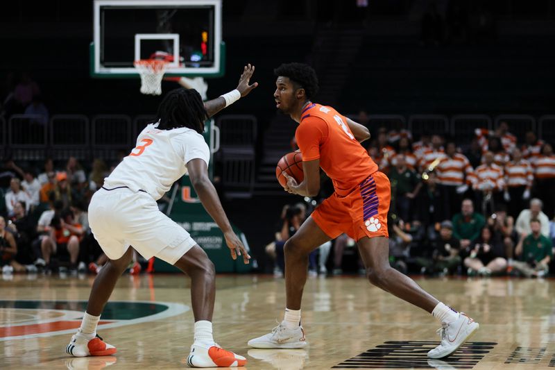 Jan 3, 2024; Coral Gables, Florida, USA; Clemson Tigers forward Chauncey Wiggins (21) protects the basketball from Miami Hurricanes guard Christian Watson (3) during the first half at Watsco Center. Mandatory Credit: Sam Navarro-USA TODAY Sports