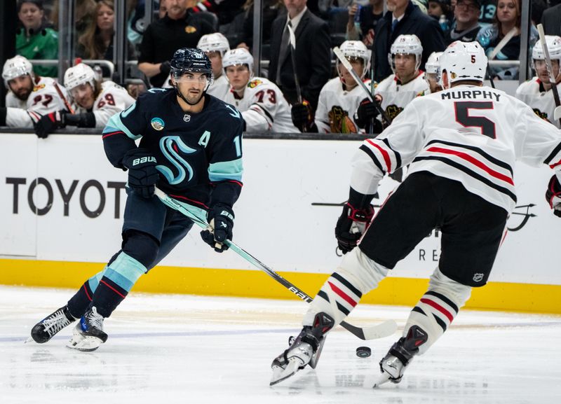 Nov 14, 2024; Seattle, Washington, USA;  Seattle Kraken forward Matty Beniers (10) skates against Chicago Blackhawks defenseman Connor Murphy (5) during the third period at Climate Pledge Arena. Mandatory Credit: Stephen Brashear-Imagn Images