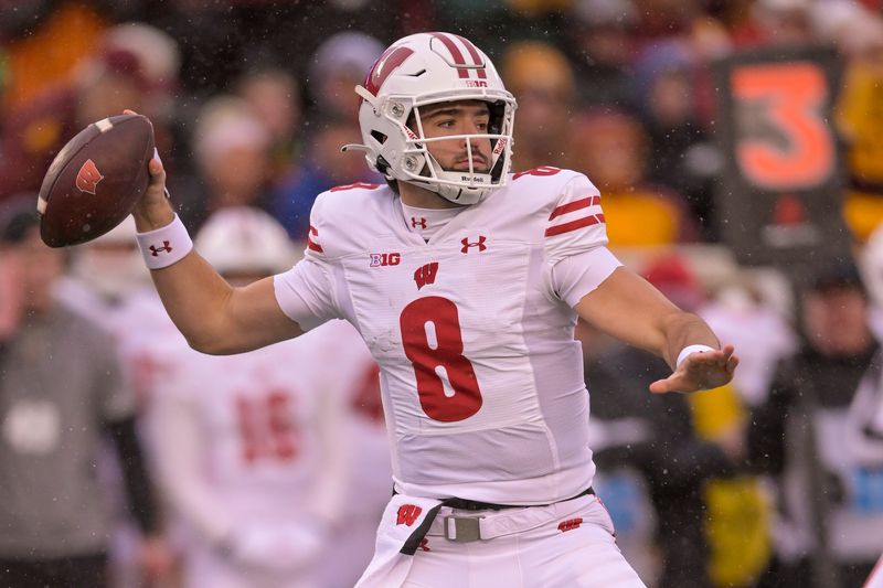 Nov 25, 2023; Minneapolis, Minnesota, USA;  Wisconsin Badgers quarterback Tanner Mordecai (8) makes a pass against the Minnesota Golden Gophers during the first quarter at Huntington Bank Stadium. Mandatory Credit: Nick Wosika-USA TODAY Sports