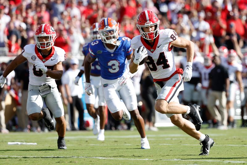 Oct 28, 2023; Jacksonville, Florida, USA; Georgia Bulldogs wide receiver Ladd McConkey (84) runs the ball past Florida Gators cornerback Jason Marshall Jr. (3) in the first half  at EverBank Stadium. Mandatory Credit: Jeff Swinger-USA TODAY Sports