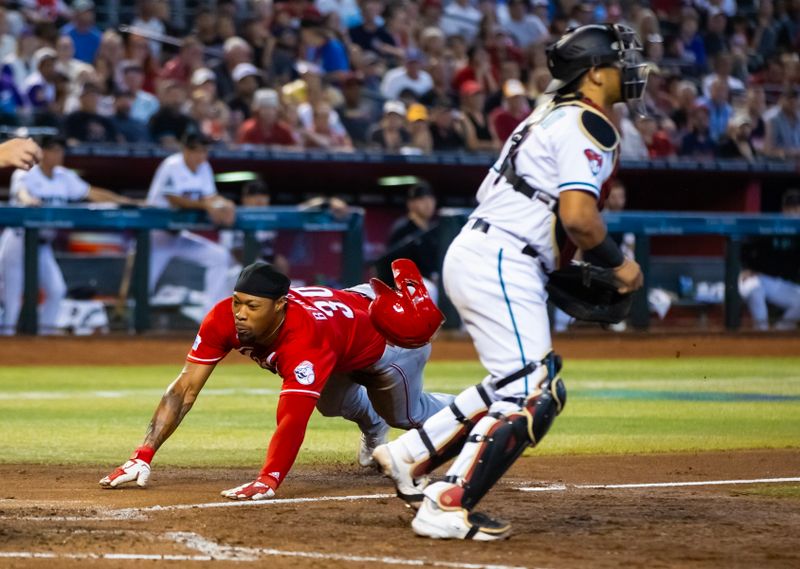 Aug 27, 2023; Phoenix, Arizona, USA; Cincinnati Reds base runner Will Benson slides into home to score a run in the sixth inning against the Arizona Diamondbacks at Chase Field. Mandatory Credit: Mark J. Rebilas-USA TODAY Sports