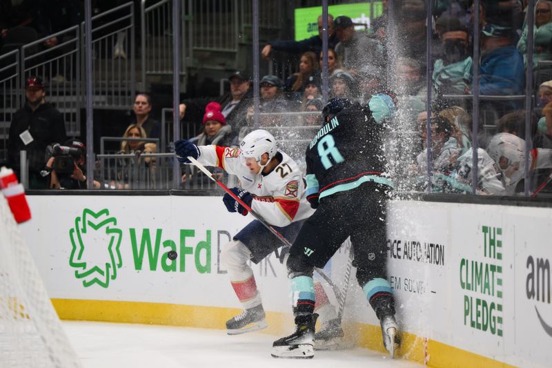 Dec 12, 2023; Seattle, Washington, USA; Florida Panthers center Eetu Luostarinen (27) checks Seattle Kraken defenseman Brian Dumoulin (8) into the wall during the first period at Climate Pledge Arena. Mandatory Credit: Steven Bisig-USA TODAY Sports.