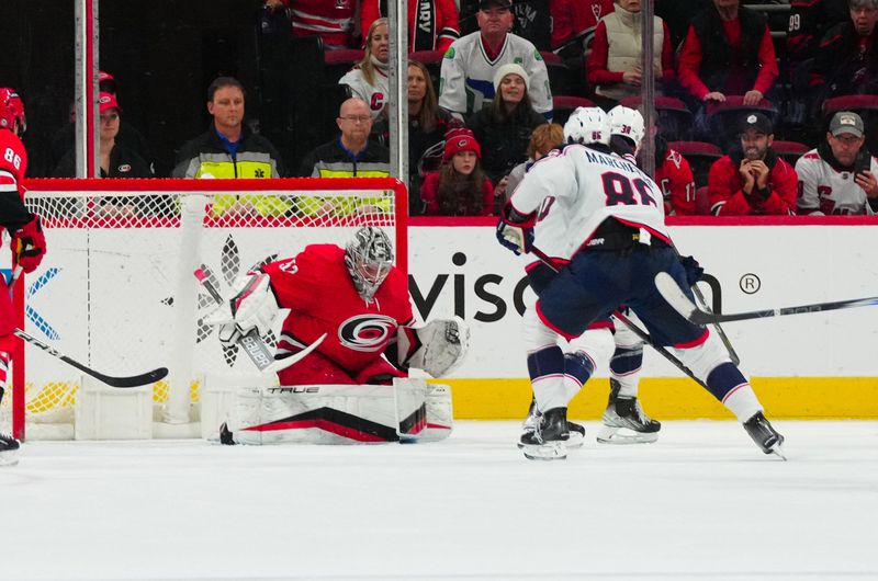 Nov 26, 2023; Raleigh, North Carolina, USA; Carolina Hurricanes goaltender Pyotr Kochetkov (52) stops the shot by Columbus Blue Jackets center Boone Jenner (38) during the third period at PNC Arena. Mandatory Credit: James Guillory-USA TODAY Sports