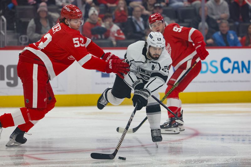 Jan 13, 2024; Detroit, Michigan, USA;  Los Angeles Kings center Phillip Danault (24) skates with the puck defended by Detroit Red Wings defenseman Moritz Seider (53) in the first period at Little Caesars Arena. Mandatory Credit: Rick Osentoski-USA TODAY Sports