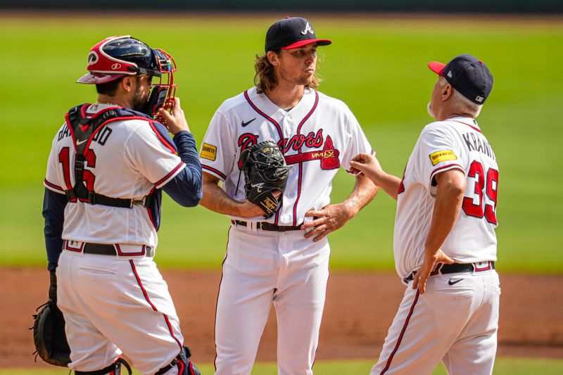 Oct 1, 2023; Cumberland, Georgia, USA; Atlanta Braves starting pitcher Dylan Dodd (46) gets a visit on the mound from catcher Travis d'Arnaud (16) and pitching coach Rick Kranitz (39) during the game against the Washington Nationals during the first inning at Truist Park. Mandatory Credit: Dale Zanine-USA TODAY Sports