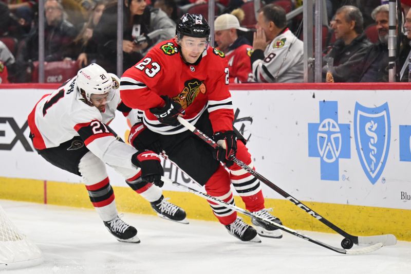 Mar 6, 2023; Chicago, Illinois, USA;  Chicago Blackhawks forward Philipp Kurashev (23) skates the puck around the net while being pursued nay Ottawa Senators forward Mathieu Joseph (21) in the first period at United Center. Mandatory Credit: Jamie Sabau-USA TODAY Sports