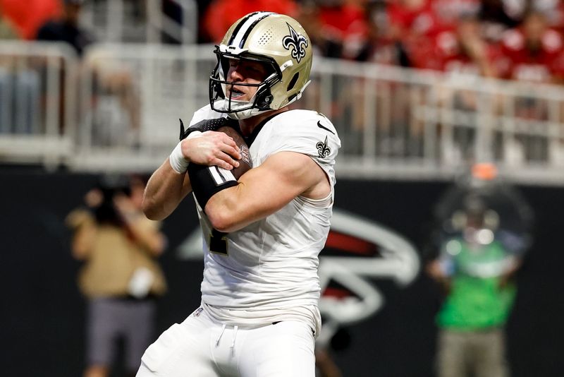 New Orleans Saints tight end Taysom Hill (7) runs into the end zone for a touchdown against the Atlanta Falcons during the first half of an NFL football game, Sunday, Sept. 29, 2024, in Atlanta. (AP Photo/Butch Dill)