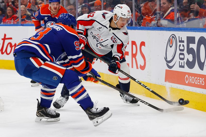 Jan 21, 2025; Edmonton, Alberta, CAN; Washington Capitals defensemen Martin Fehervary (42) and Edmonton Oilers forward Ryan Nugent-Hopkins (93) battle along the boards for a loose puck during the first period at Rogers Place. Mandatory Credit: Perry Nelson-Imagn Images