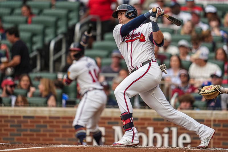 Jul 4, 2024; Cumberland, Georgia, USA; Atlanta Braves third baseman Austin Riley (27) hits a sacrifice fly ball to drive in a run against the San Francisco Giants during the first inning at Truist Park. Mandatory Credit: Dale Zanine-USA TODAY Sports