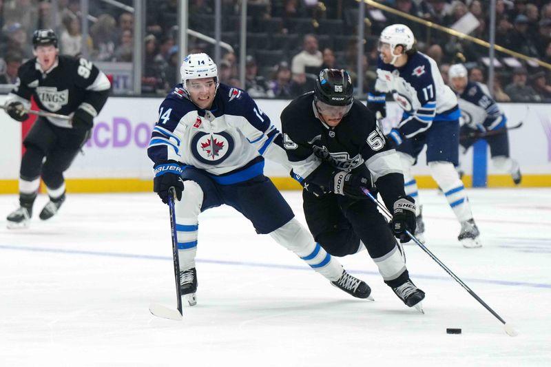 Nov 27, 2024; Los Angeles, California; LA Kings right wing Quinton Byfield (55) and Winnipeg Jets defenseman Ville Heinola (14) battle for the puck in the second period at Crypto.com Arena. Mandatory Credit: Kirby Lee-Imagn Images