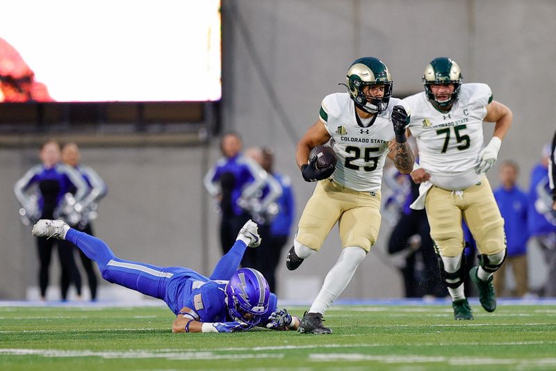 Oct 19, 2024; Colorado Springs, Colorado, USA; Colorado State Rams running back Avery Morrow (25) runs through the tackle of Air Force Falcons defensive back Lincoln Tuioti-Mariner (23) as offensive lineman Jacob Gardner (75) looks on in the first quarter at Falcon Stadium. Mandatory Credit: Isaiah J. Downing-Imagn Images