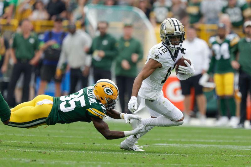 New Orleans Saints wide receiver Chris Olave (12) carries against Green Bay Packers cornerback Corey Ballentine (35) during the second half of an NFL football game Sunday, Sept. 24, 2023, in Green Bay, Wis. (AP Photo/Matt Ludtke)