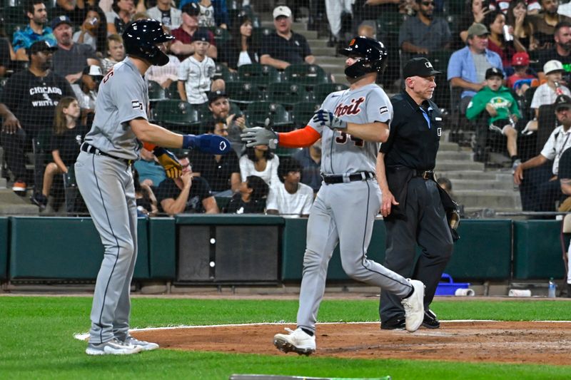 Sep 1, 2023; Chicago, Illinois, USA; Detroit Tigers center fielder Parker Meadows (22), left, congratulates catcher Jake Rogers (34) after scoring against the Chicago White Sox during the fifth inning at Guaranteed Rate Field. Mandatory Credit: Matt Marton-USA TODAY Sports