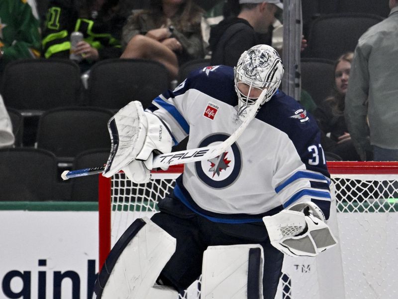 Apr 10, 2025; Dallas, Texas, USA; Winnipeg Jets goaltender Connor Hellebuyck (37) celebrates on the ice after getting the shutout win over the Dallas Stars at the American Airlines Center. Mandatory Credit: Jerome Miron-Imagn Images