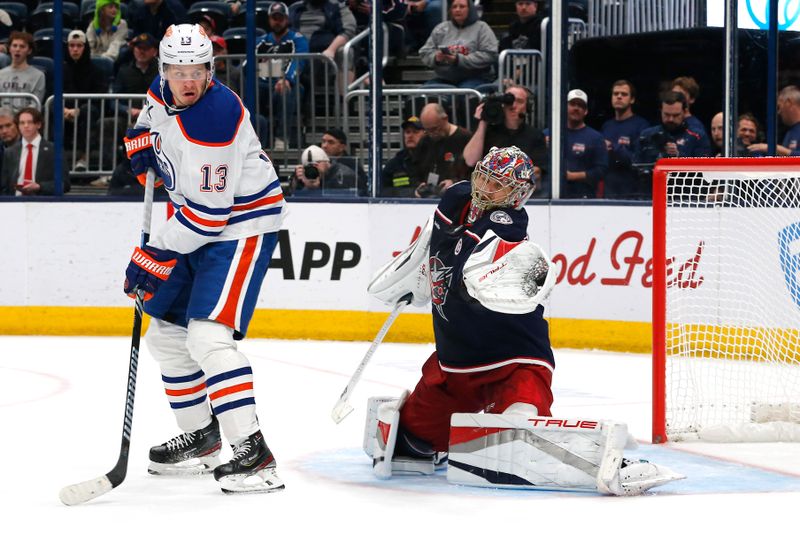 Oct 28, 2024; Columbus, Ohio, USA; Columbus Blue Jackets goalie Elvis Merzlikins (90) makes a glove save as Edmonton Oilers center Mattias Janmark (13) looks for a rebound during the third period at Nationwide Arena. Mandatory Credit: Russell LaBounty-Imagn Images