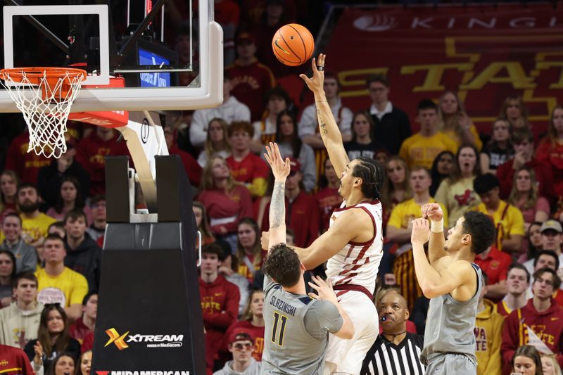 Feb 24, 2024; Ames, Iowa, USA; Iowa State Cyclones forward Robert Jones (12) shoots over West Virginia Mountaineers forward Quinn Slazinski (11) during the second half at James H. Hilton Coliseum. Mandatory Credit: Reese Strickland-USA TODAY Sports