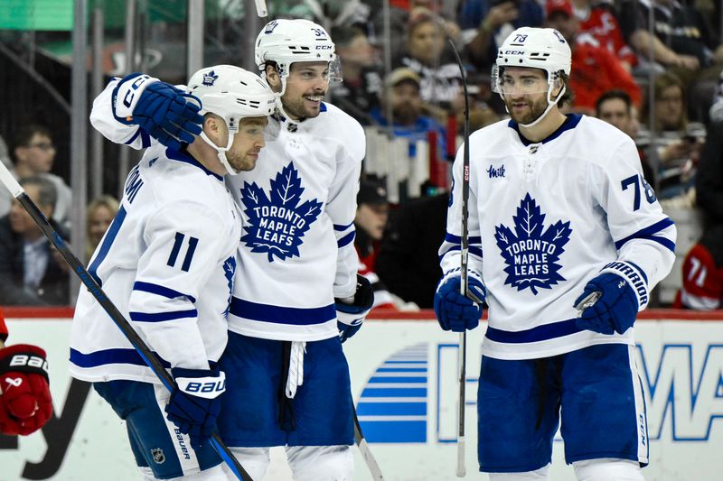 Apr 9, 2024; Newark, New Jersey, USA; Toronto Maple Leafs center Auston Matthews (34) celebrates with Toronto Maple Leafs center Max Domi (11) and Toronto Maple Leafs defenseman TJ Brodie (78) after scoring a goal against the New Jersey Devils during the third period at Prudential Center. Mandatory Credit: John Jones-USA TODAY Sports