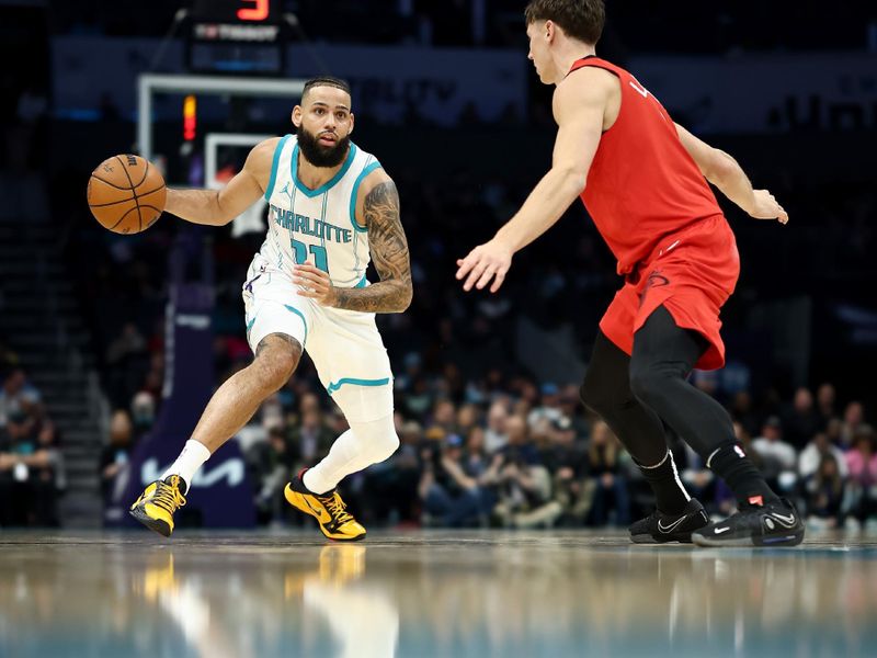 CHARLOTTE, NORTH CAROLINA - NOVEMBER 27: Cody Martin #11 of the Charlotte Hornets dribbles against Pelle Larsson #9 of the Miami Heat during the first half of the game at Spectrum Center on November 27, 2024 in Charlotte, North Carolina. NOTE TO USER: User expressly acknowledges and agrees that, by downloading and or using this photograph, User is consenting to the terms and conditions of the Getty Images License Agreement. (Photo by Jared C. Tilton/Getty Images)