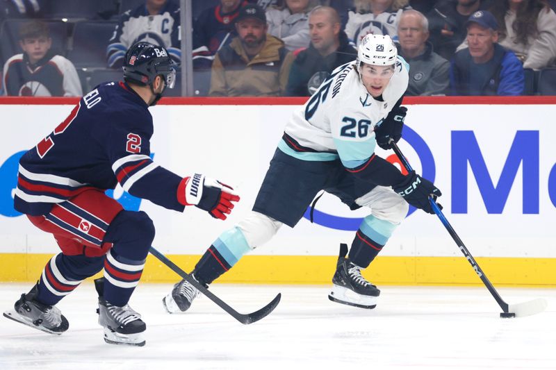 Oct 23, 2025; Winnipeg, Manitoba, CAN; Seattle Kraken center Ryan Winterton (26) skates past Winnipeg Jets defenseman Dylan Demelo (2) in the first period at Canada Life Centre. Mandatory Credit: James Carey Lauder-Imagn Images