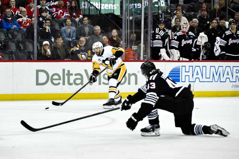 Apr 11, 2025; Newark, New Jersey, USA; Pittsburgh Penguins right wing Bryan Rust (17) shoots and scores a goal as New Jersey Devils defenseman Luke Hughes (43) defends during the third period at Prudential Center. Mandatory Credit: John Jones-Imagn Images