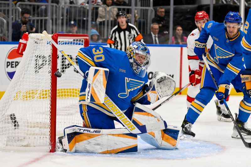 Oct 19, 2024; St. Louis, Missouri, USA;  St. Louis Blues goaltender Joel Hofer (30) defends the net against the Carolina Hurricanes during the first period at Enterprise Center. Mandatory Credit: Jeff Curry-Imagn Images