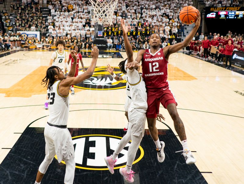 Jan 31, 2024; Columbia, Missouri, USA; Arkansas Razorbacks guard Tramon Mark (12) shoots against Missouri Tigers guard Anthony Robinson II (14) and forward Aidan Shaw (23) during the first half at Mizzou Arena. Mandatory Credit: Jay Biggerstaff-USA TODAY Sports