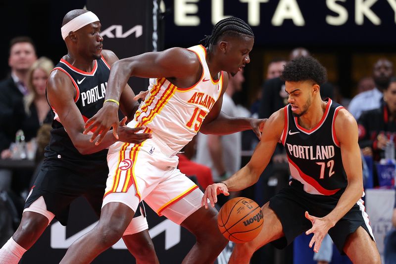 ATLANTA, GEORGIA - MARCH 27:  Duop Reath #26 of the Portland Trail Blazers knocks the ball away from Clint Capela #15 of the Atlanta Hawks into the hands of Rayan Rupert #72 during the first quarter at State Farm Arena on March 27, 2024 in Atlanta, Georgia.  NOTE TO USER: User expressly acknowledges and agrees that, by downloading and/or using this photograph, user is consenting to the terms and conditions of the Getty Images License Agreement.  (Photo by Kevin C. Cox/Getty Images)