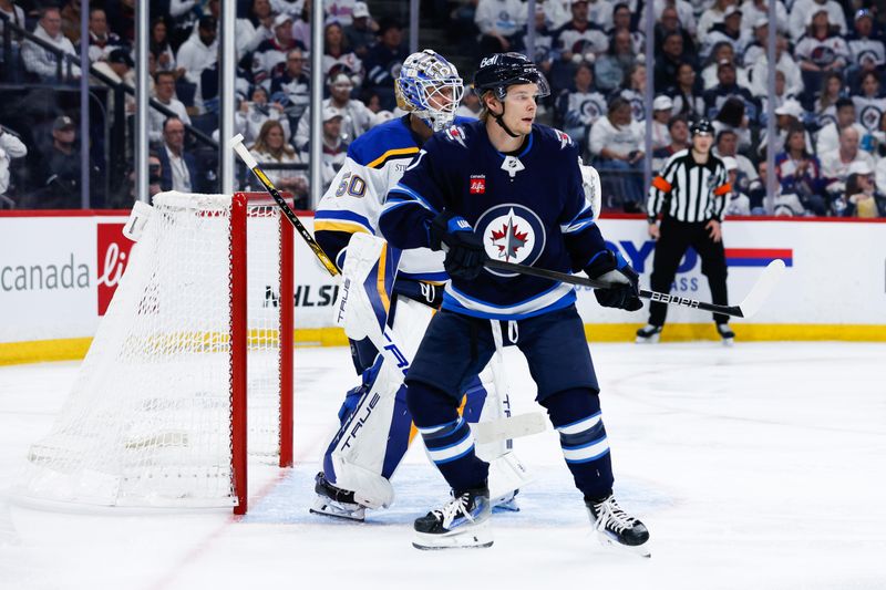 Apr 30, 2025; Winnipeg, Manitoba, CAN; St. Louis Blues goalie Jordan Binnington (50) and Winnipeg Jets forward Vladislav Namestnikov (7) look for the puck during the second period in game five of the first round of the 2025 Stanley Cup Playoffs at Canada Life Centre. Mandatory Credit: Terrence Lee-Imagn Images