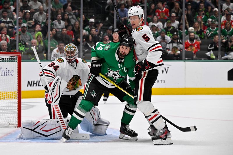 Oct 26, 2024; Dallas, Texas, USA; Dallas Stars left wing Jamie Benn (14) battles for position between Chicago Blackhawks goaltender Petr Mrazek (34) and defenseman Connor Murphy (5) during the second period at the American Airlines Center. Mandatory Credit: Jerome Miron-Imagn Images