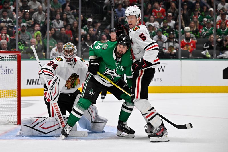 Oct 26, 2024; Dallas, Texas, USA; Dallas Stars left wing Jamie Benn (14) battles for position between Chicago Blackhawks goaltender Petr Mrazek (34) and defenseman Connor Murphy (5) during the second period at the American Airlines Center. Mandatory Credit: Jerome Miron-Imagn Images